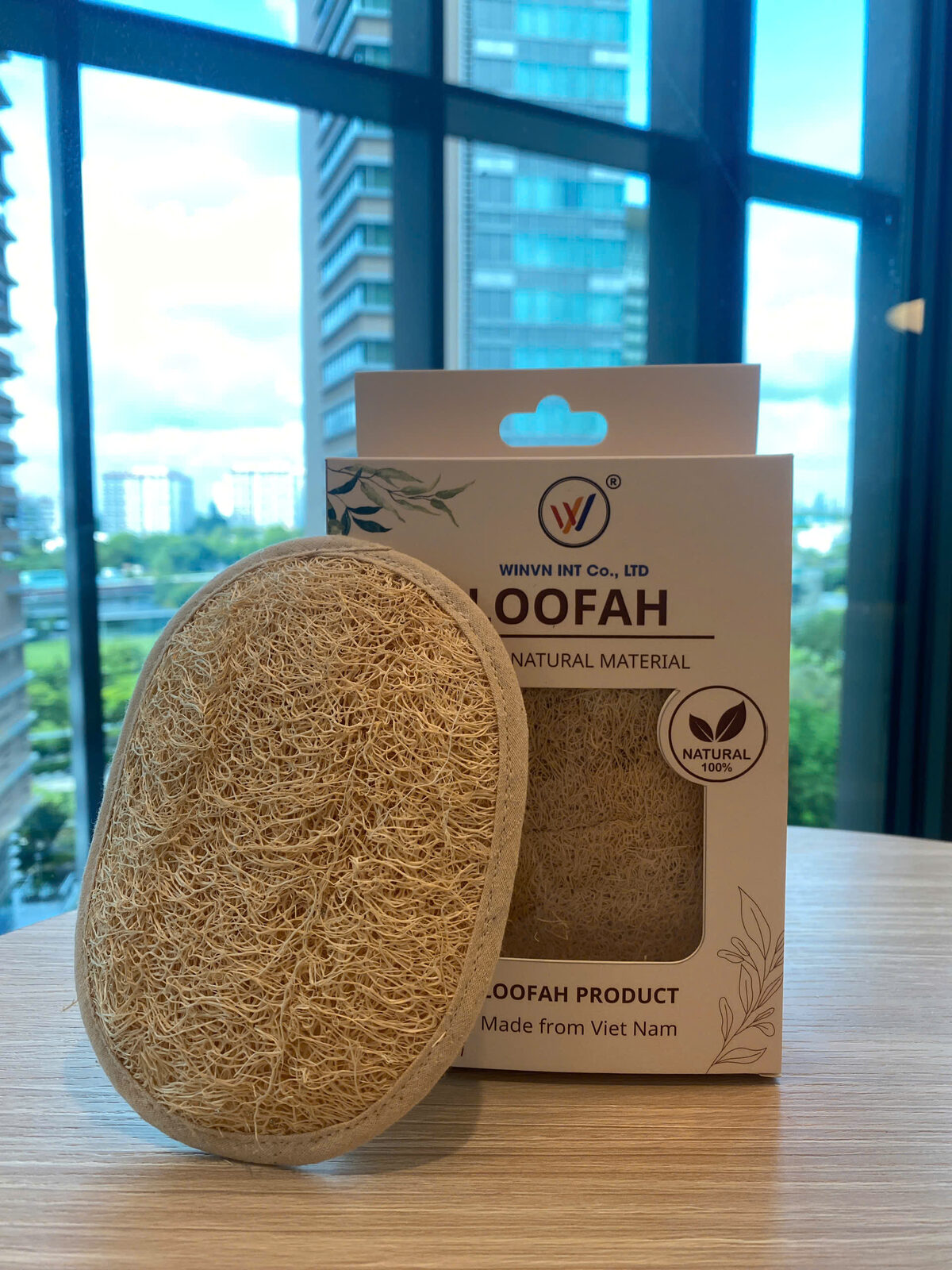 WINVN branded loofah packaging sample next to the natural loofah bath pad